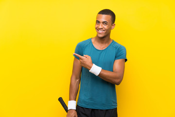 African American tennis player man pointing to the side to present a product