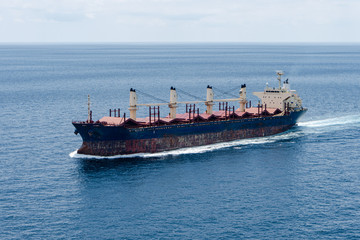 A old bulk carrier or bulker sails in the sea to trade around the world