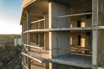Obraz premium Aerial view of concrete frame of tall apartment building under construction in a city.