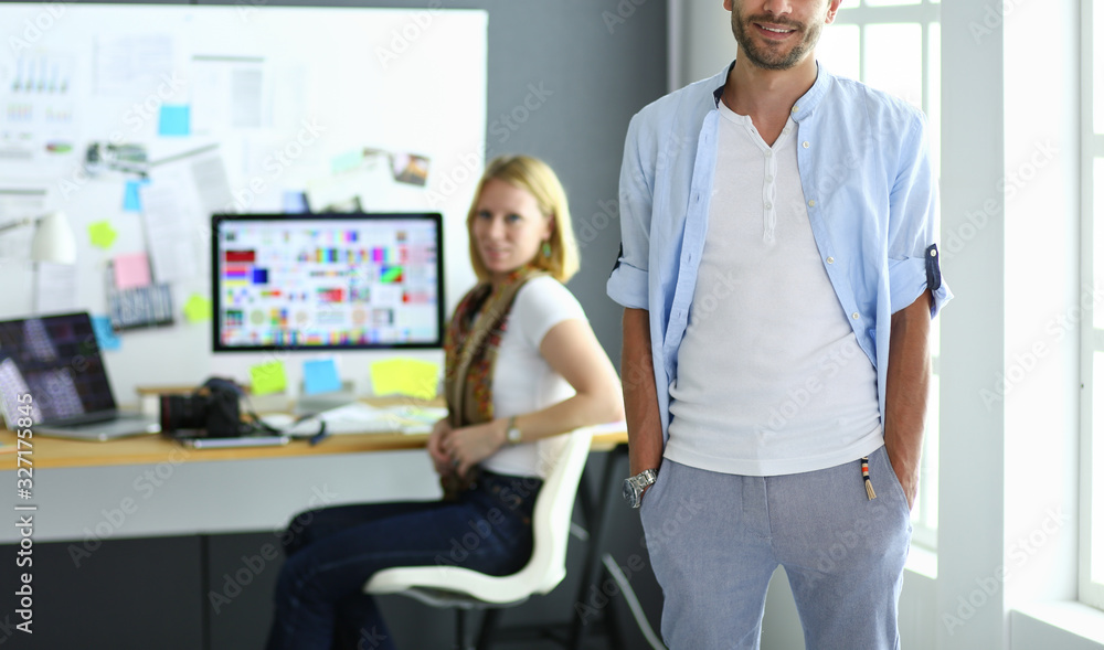 Poster portrait of young designer in front of laptop and computer while working. assistant using her mobile
