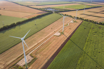 Aerial view of wind turbine generators in field producing clean ecological electricity.