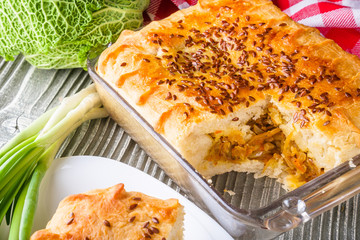 freshly baked cabbage pie on rustic wooden background