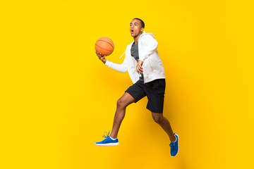 Fototapeta premium Afro American basketball player man over isolated yellow background