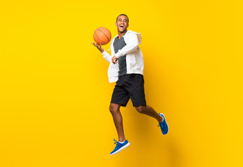 Afro American basketball player man over isolated yellow background