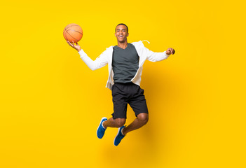 Fototapeta premium Afro American basketball player man over isolated yellow background