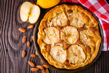 crispy apple galette with almonds on rustic wooden background