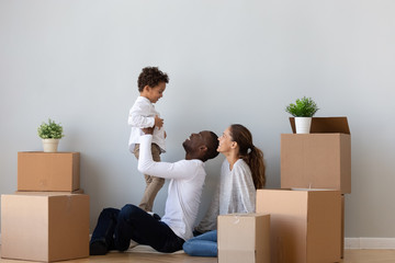 Happy African American family with little son celebrating relocation