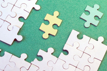 Yellow and Green puzzle moves to white puzzles on a green background