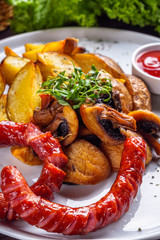 baked potatoes with sausages on a wooden rustic background