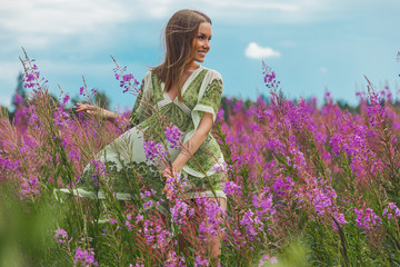 beautiful young woman in a green dress and pink lavender fields, Chamaenérion angustifolium