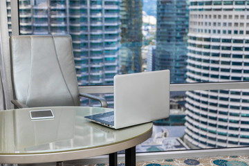 laptop and business workplace with a view of skyscrapers in a business center