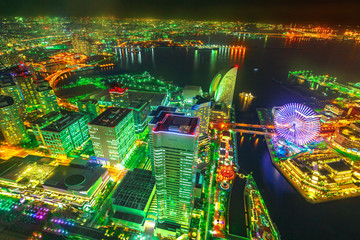 Panoramic view of Yokohama Skyline and Minato Mirai waterfront district with ferris wheel by night from viewing platform, observatory sky garden of Landmark Tower.