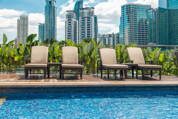 sun loungers by the rooftop pool against the background of Kuala Lumpur skyscrapers