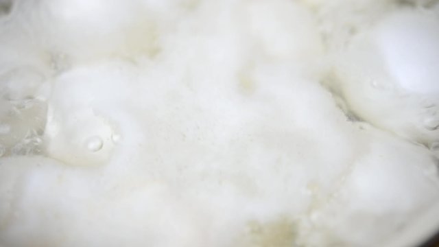 Top view close-up of chicken eggs boiled in a pan in the kitchen on the stove. Cooking food.