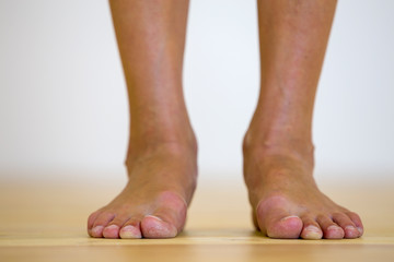 Woman bare feet on the floor. Legs care and skin treatment concept.