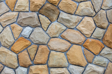 Abstract wall surface made from sand stones for usage as background.