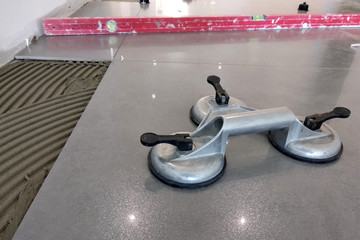 Ceramic tiles and tools for tiler. Floor tiles installation. Home improvement, renovation - ceramic tile floor adhesive, mortar, level