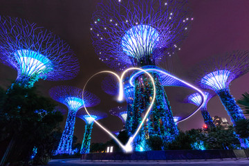 luminous heart on a background of trees in a marina bay garden in singapore.