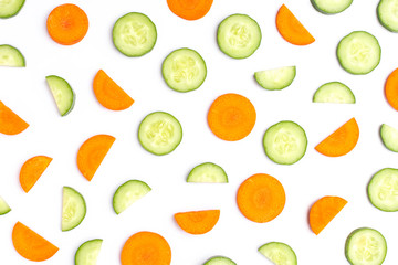 Cucumber and carrot slices isolated on white background. Top view. Flat lay.