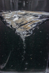 swirling spinning water in a glass with bubbles isolated on a black background