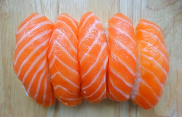 Top eye view closeups of delicious sliced salmon sushi sashimi five bite for serving isolated on  wooden background a
