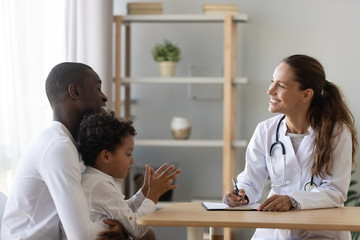 Smiling pediatrician doctor consulting African American father about son health
