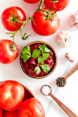 Homemade tomato sause near ingredients - garlic, spices - on white background top-down