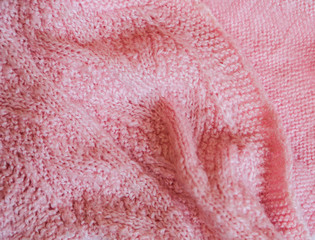 Pink knitted background. Close up gray fabric texture background. wrinkled and shadows, selective focus top view