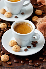 Almond cookies and cup of aromatic coffee on wooden table
