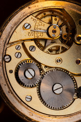 Close up of an authentic 100 hundred years old pocket watch mechanism cogs and wheels , golden