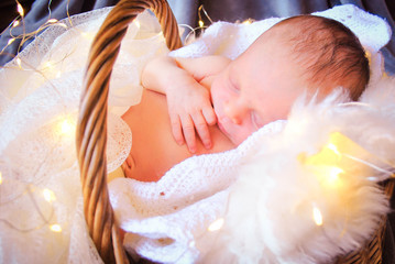 Bebe newborn en canasta durmiendo con lucecitas