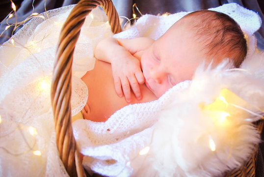 Bebe newborn en canasta durmiendo con lucecitas