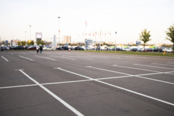 No cars on the parking. Empty parking slots. Road marking on the asphalt pavement. Summer. Outdoor. Out of focus. Blurred...