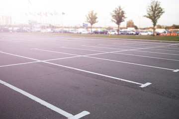 No cars on the parking. Empty parking slots. Road marking on the asphalt pavement. Summer. Outdoor. Out of focus. Blurred...