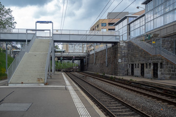 Concrete stairway at empty platform at train station in Zurich midtown with modern buildings on cloudy sky background , copy space , Switzerland