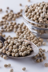 white peppercorns in glass bowl with spoon