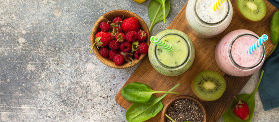 Fototapeta na wymiar The concept of a healthy diet and diet. Green Detox mixed smoothies vegetable and fruit with organic ingredients on a stone concrete worktop. Top view flat lay background. Copy space. Banner.