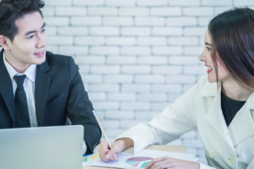 Smiling Asian business woman hold pecil, take note while listening to suggestions from manager. Smart coworkers discuss, brainstorm for operating performance report. Communication and business concept