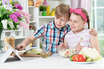 Cute brother and sister cooking together in kitchen