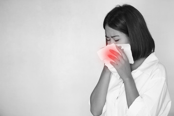 Viruses, Portrait of young woman blowing her nose after catching a cold on white background, illness, Health concept