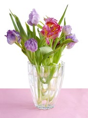 posy of multicolor tulips in glass vase close up