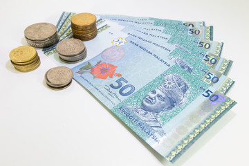 Malaysia Currency (MYR): Stack of Ringgit Malaysia bank note. There is a Malaysia banknotes in (MYR)50 and coins isolated on white background