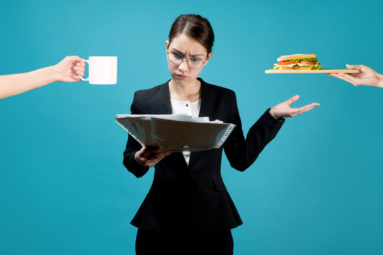 The female boss is carefully studying the documents and have cnack on the go