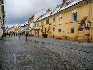 People walking on the colorful  medieval streets at wintertime i Brasov, Romania.