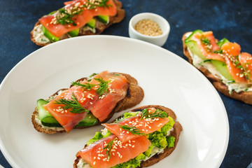 homemade  open sandwiches with salmon avocado cucumber  cream cheese dill on plate