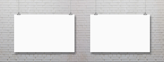 Blank white poster on brick wall hanging under decorative vintage light