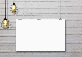 White paper or poster hanging by a clip on a concrete wall background.