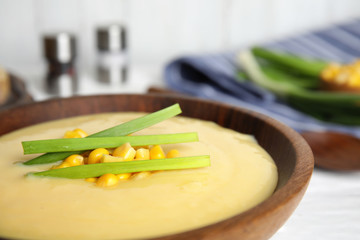 Delicious corn cream soup in wooden bowl, closeup
