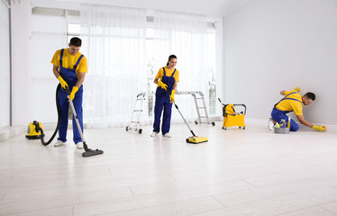 Team of professional janitors cleaning room after renovation