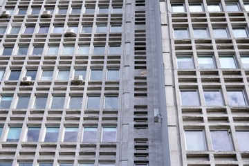 Facade of an old industrial office building with a predominance of old cement and old structural elements.